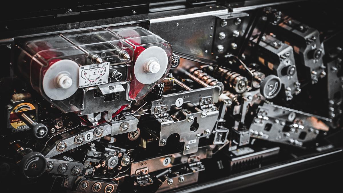 A person using compressed air to clean the internals of a gaming laptop, ensuring optimal performance and longevity.